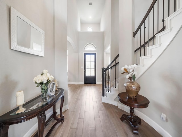 foyer featuring light hardwood / wood-style flooring and a high ceiling