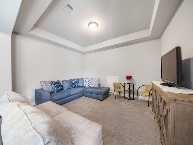 carpeted living room with a raised ceiling