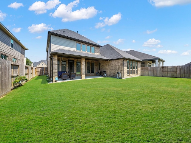 rear view of house featuring a yard and a patio