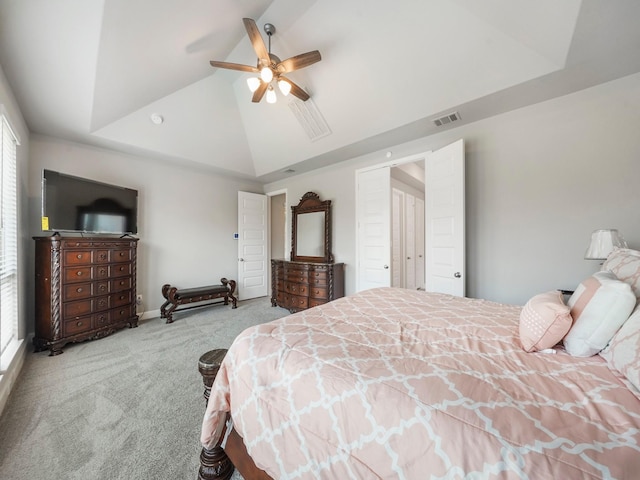 carpeted bedroom with ceiling fan, a raised ceiling, and multiple windows