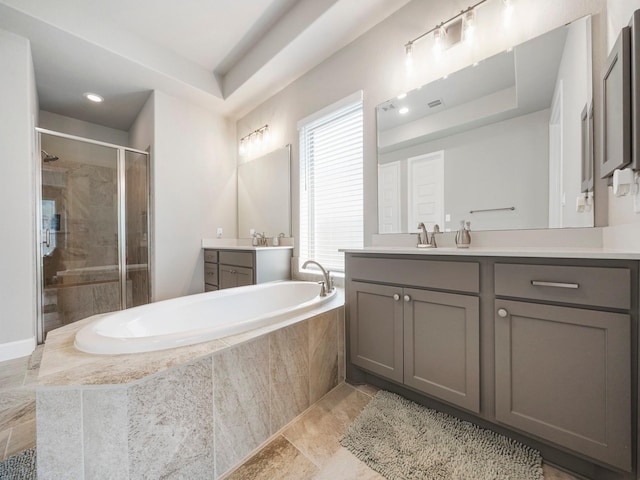 bathroom featuring vanity and independent shower and bath