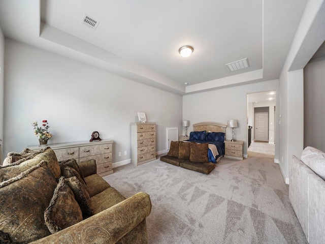 bedroom featuring light carpet and a tray ceiling