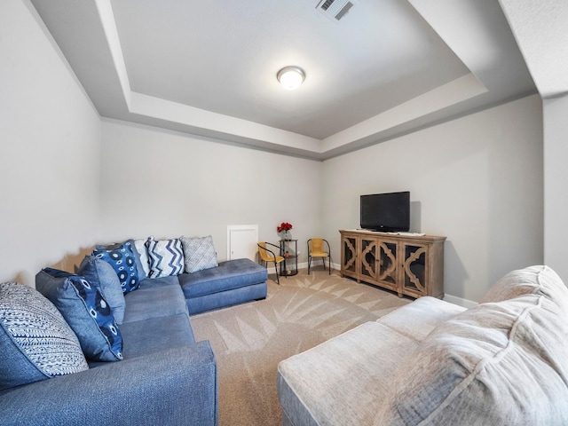 carpeted living room with a raised ceiling