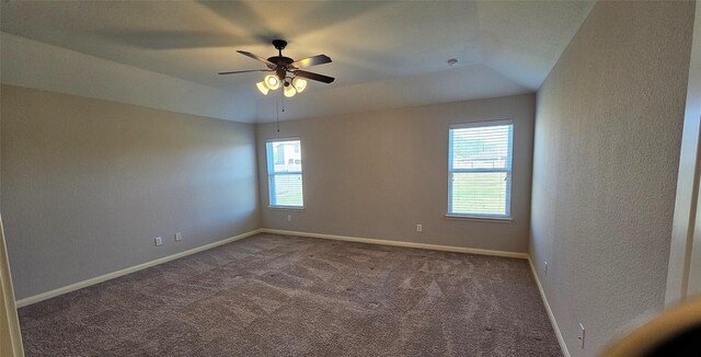 unfurnished room with ceiling fan and dark colored carpet