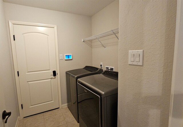 laundry room with light tile patterned flooring and washing machine and clothes dryer