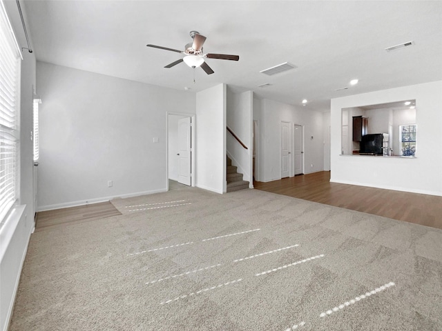 unfurnished living room featuring hardwood / wood-style floors, plenty of natural light, and ceiling fan