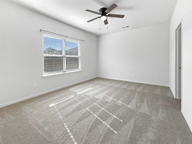 carpeted spare room featuring ceiling fan