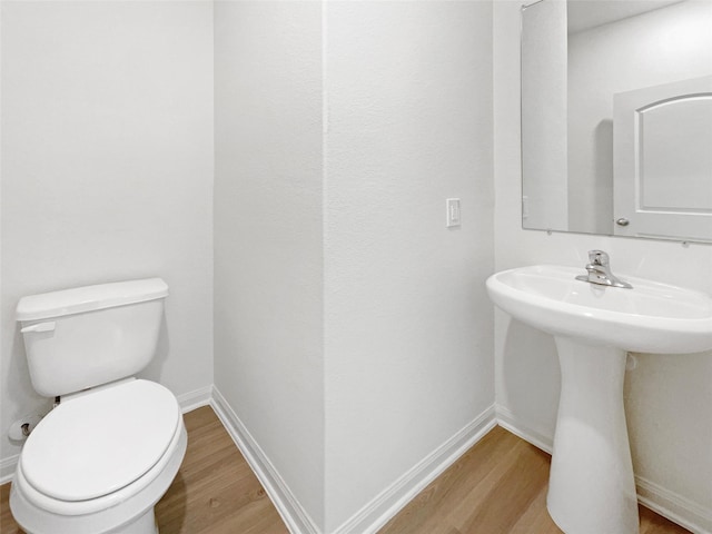 bathroom featuring hardwood / wood-style floors, toilet, and sink