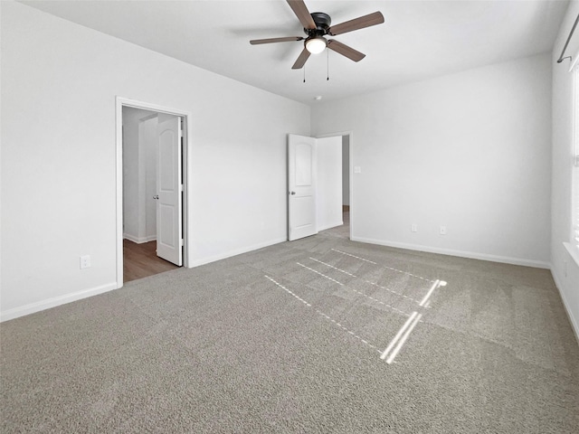 unfurnished bedroom with ceiling fan and dark carpet