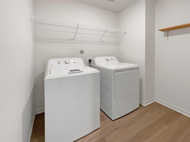 laundry room featuring light hardwood / wood-style floors and washing machine and dryer