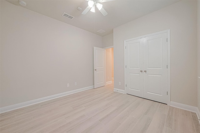 unfurnished bedroom with a closet, light hardwood / wood-style floors, and ceiling fan