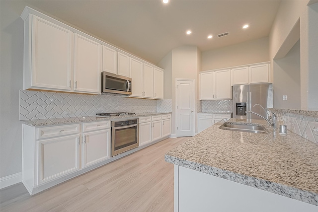 kitchen featuring white cabinetry, light wood-type flooring, sink, and appliances with stainless steel finishes