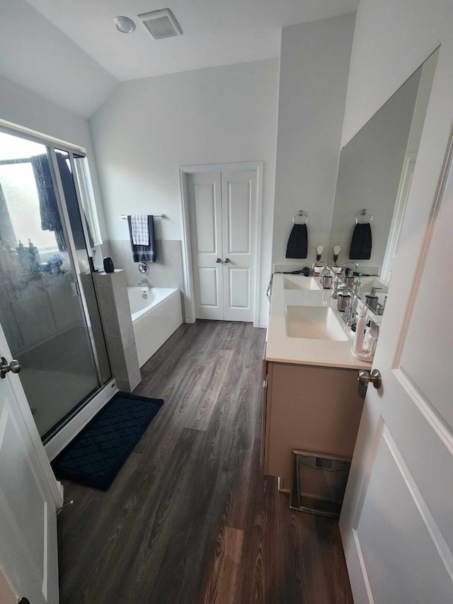 bathroom featuring vanity, hardwood / wood-style floors, separate shower and tub, and vaulted ceiling