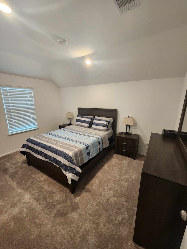 bedroom with dark colored carpet and vaulted ceiling