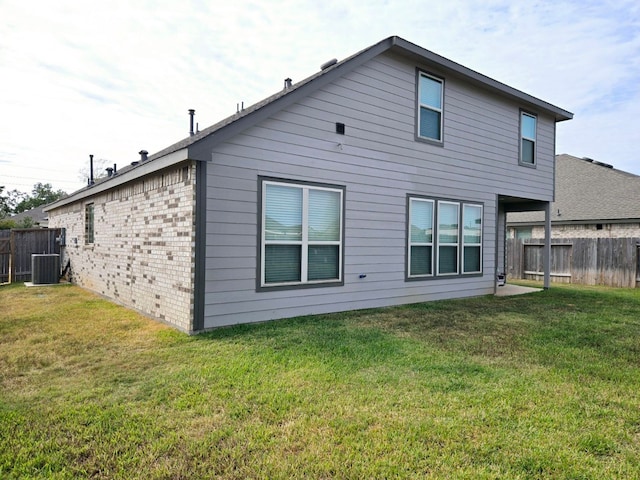 back of property featuring a yard and central AC