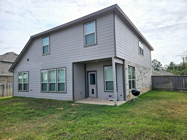 rear view of property featuring a yard and a patio area