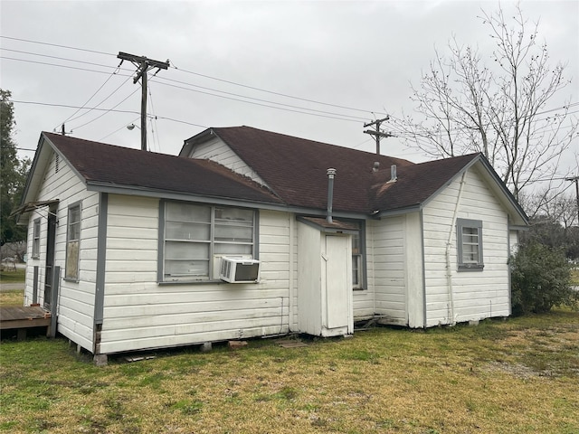 rear view of house featuring a lawn and cooling unit