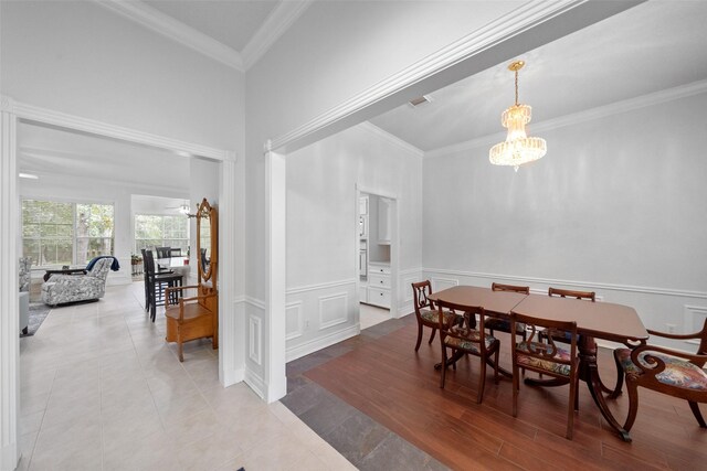 dining area with a notable chandelier, ornamental molding, and hardwood / wood-style floors