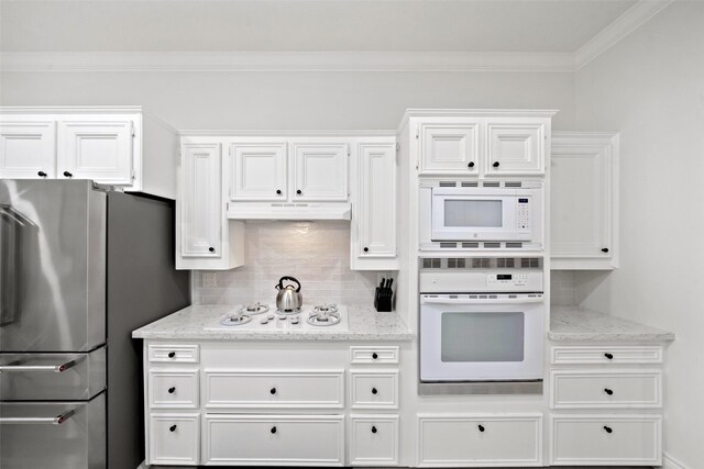 kitchen featuring decorative backsplash, white appliances, light stone countertops, and white cabinets