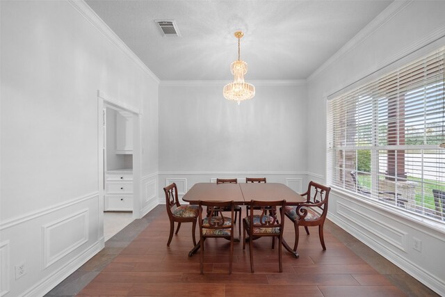 dining area with a chandelier, dark hardwood / wood-style floors, and crown molding