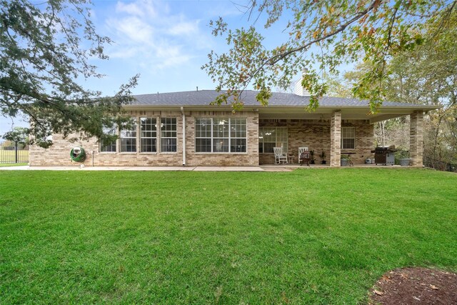 rear view of house featuring a patio and a lawn