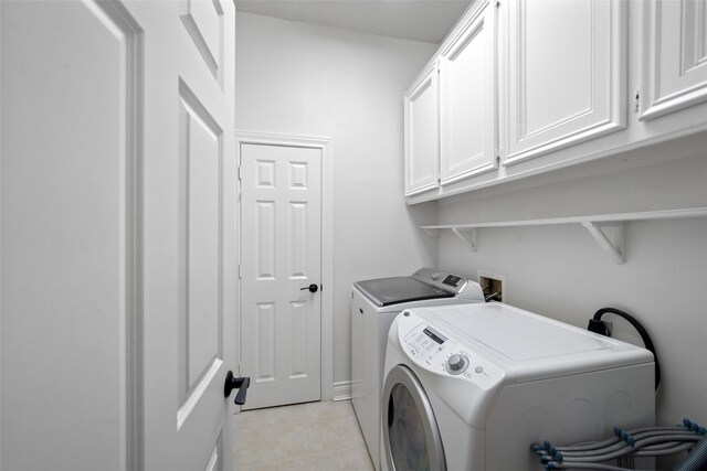 washroom featuring cabinets, washer and dryer, and light tile patterned floors