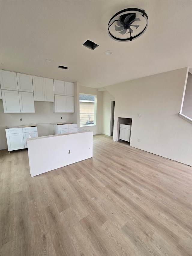 kitchen featuring white cabinetry, light hardwood / wood-style flooring, and a center island