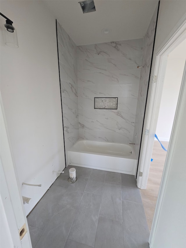 bathroom featuring tiled shower / bath combo and tile patterned flooring