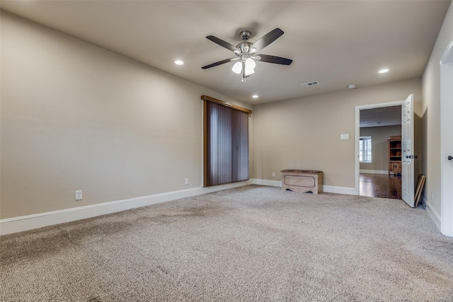 carpeted spare room featuring ceiling fan