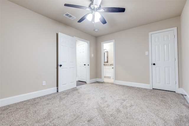 unfurnished bedroom featuring carpet, ensuite bathroom, and ceiling fan