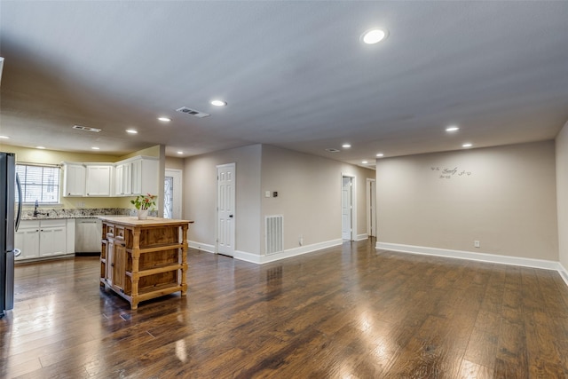 kitchen with a center island, dark wood-type flooring, stainless steel appliances, and white cabinets