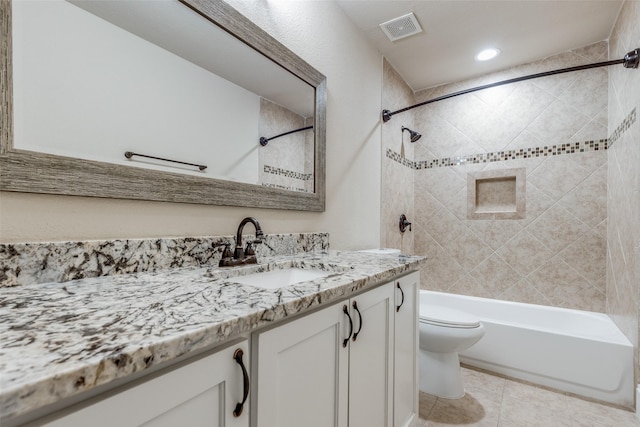 full bathroom with tile patterned floors, vanity, toilet, and tiled shower / bath combo