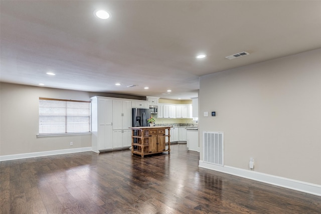 kitchen featuring dark hardwood / wood-style flooring, stainless steel appliances, and white cabinetry