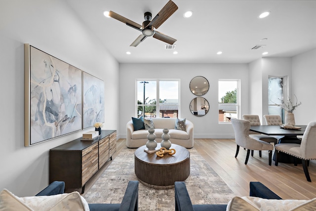 living room featuring ceiling fan and light hardwood / wood-style flooring