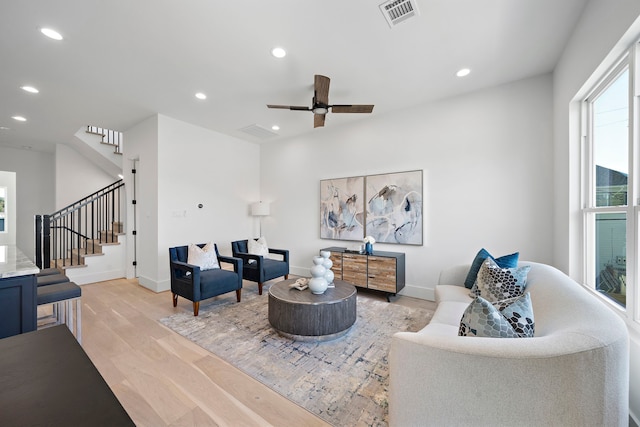 living room with light hardwood / wood-style floors and ceiling fan