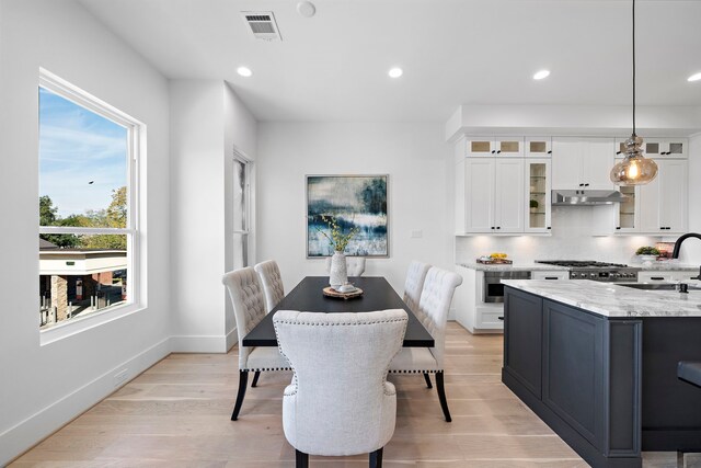 dining area with light wood-type flooring and sink