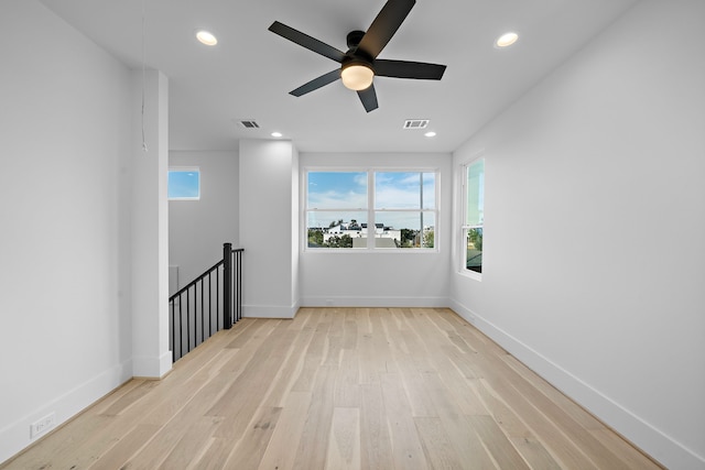 unfurnished room featuring plenty of natural light, light hardwood / wood-style floors, and ceiling fan