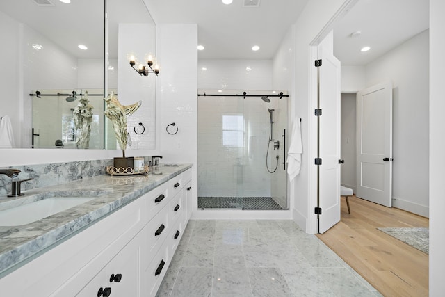 bathroom featuring vanity, wood-type flooring, and a shower with shower door