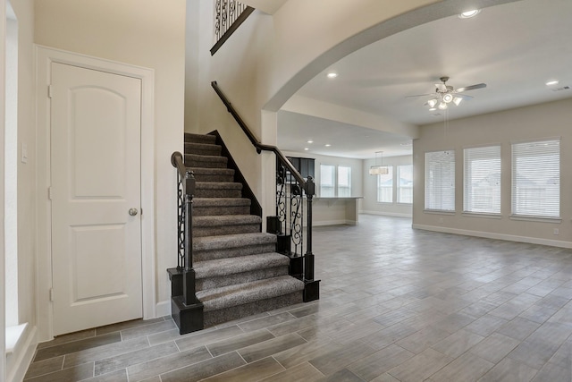 stairs featuring ceiling fan