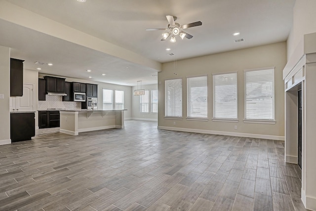 unfurnished living room featuring ceiling fan