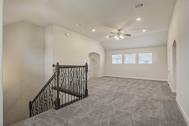 empty room featuring ceiling fan, light carpet, and vaulted ceiling