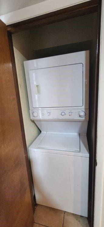 laundry area with tile patterned floors and stacked washer / dryer