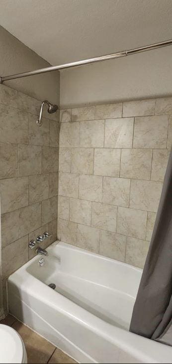 bathroom with toilet, tile patterned floors, and shower / bathtub combination with curtain