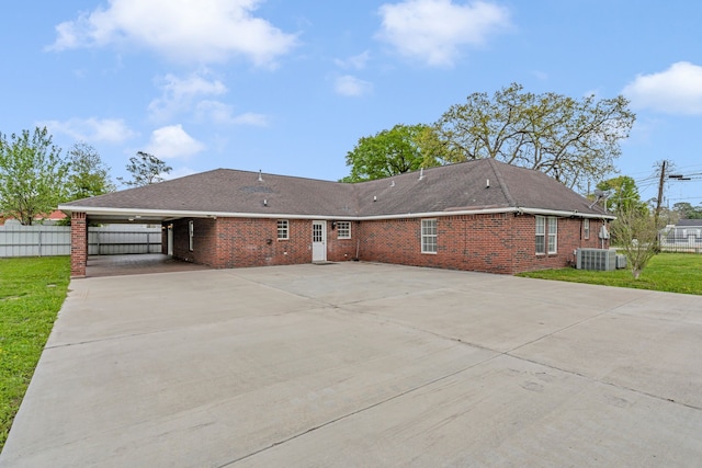 back of property featuring central AC and a carport