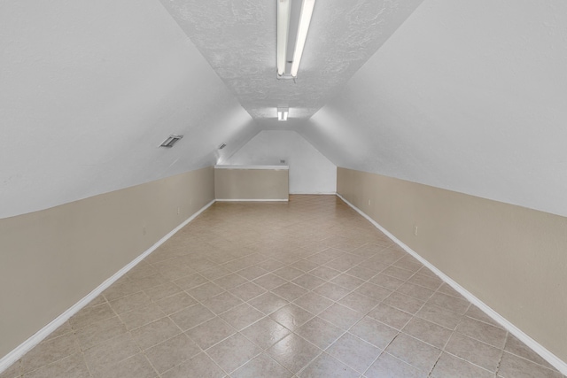 bonus room featuring a textured ceiling and vaulted ceiling