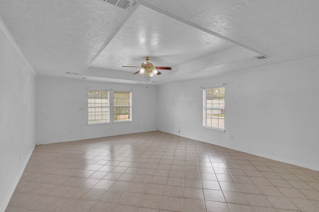 spare room featuring a tray ceiling, ceiling fan, crown molding, and light tile patterned flooring