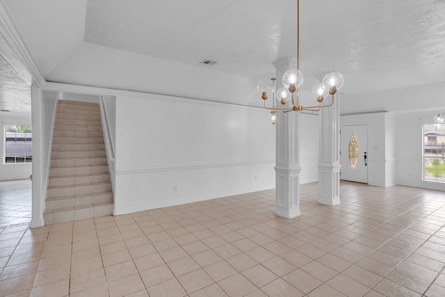 interior space featuring light tile patterned floors, a textured ceiling, and a notable chandelier