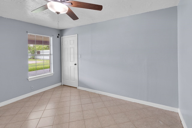 tiled spare room featuring a textured ceiling and ceiling fan