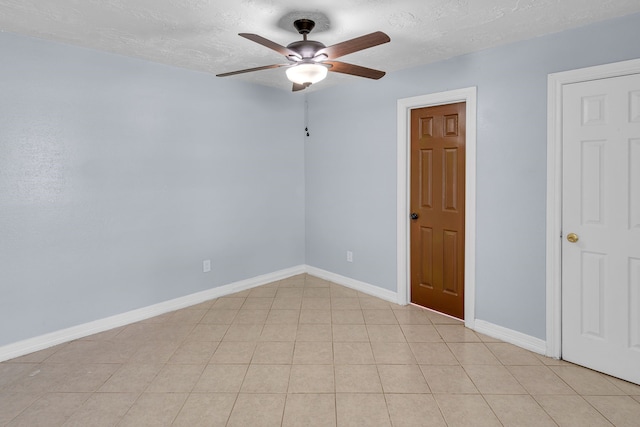 tiled spare room featuring ceiling fan and a textured ceiling