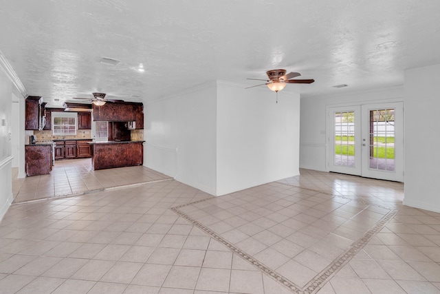 unfurnished living room with crown molding, french doors, light tile patterned floors, and a textured ceiling